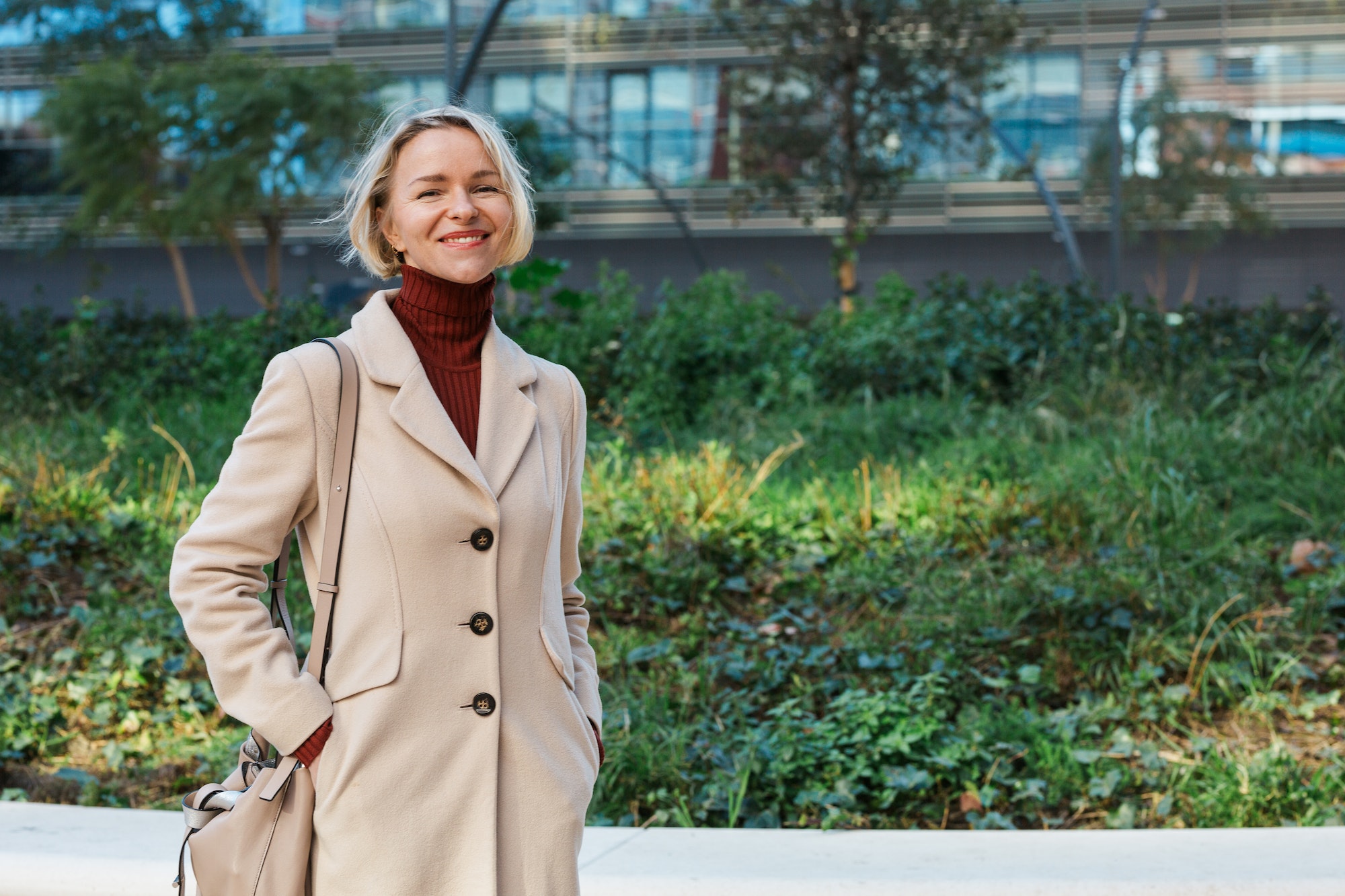 stylish-business-woman-smiling-while-standing-outdoors-in-the-financial-district.jpg